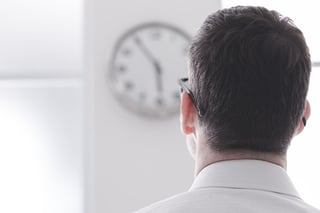 man looking at clock