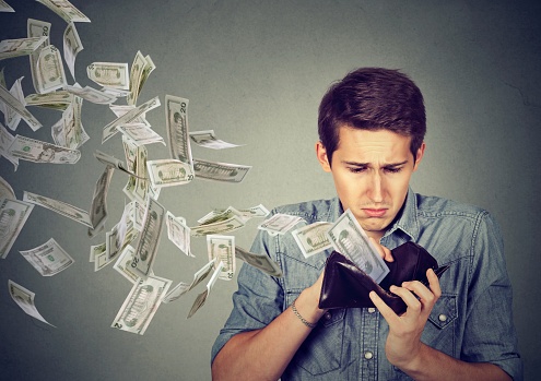 638948636_man with money flying out of wallet to pay debt