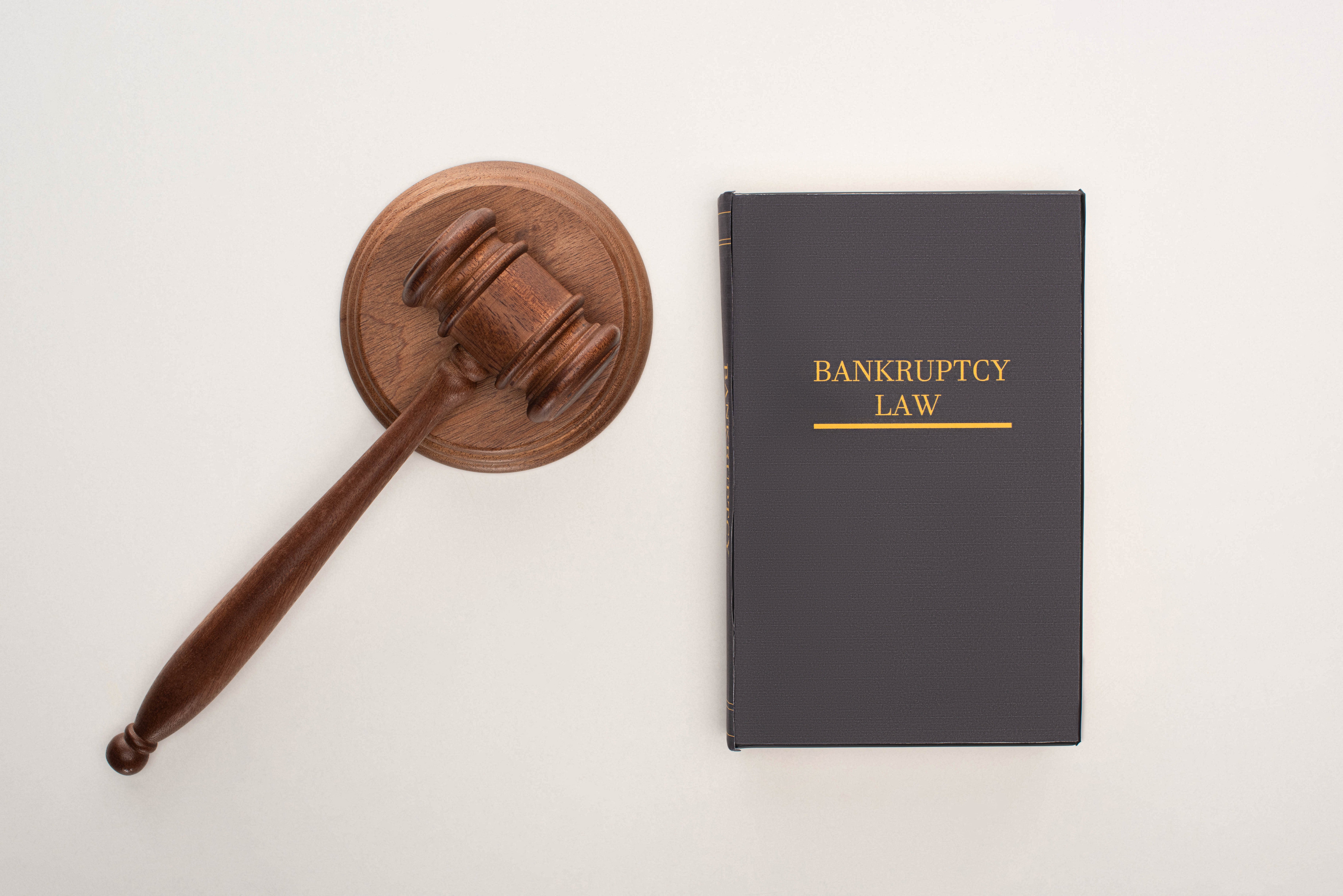 top-view-of-bankruptcy-law-book-and-gavel-on-white-2022-12-16-15-52-21-utc