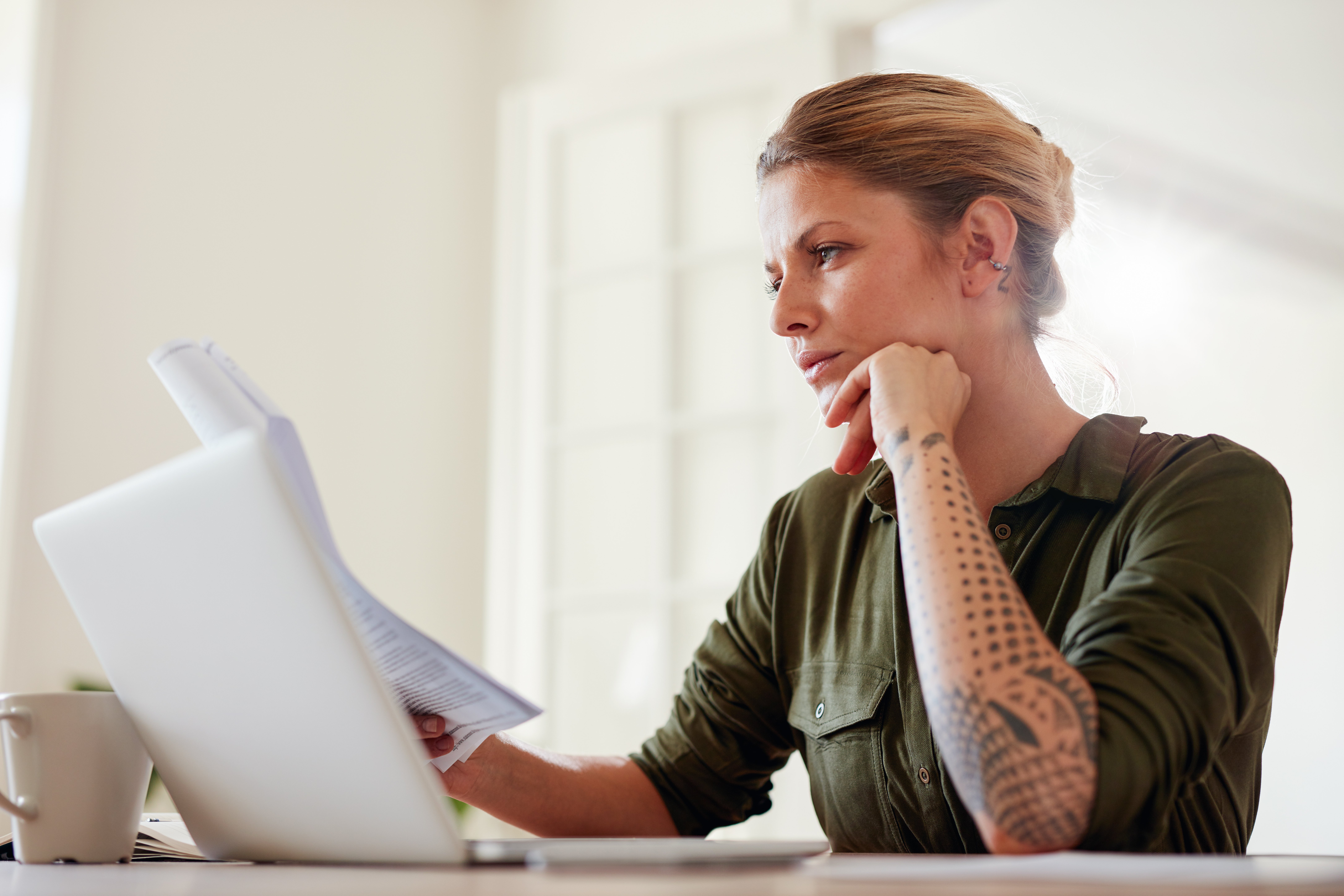 young-woman-reading-documents-at-home-PH8UR5N