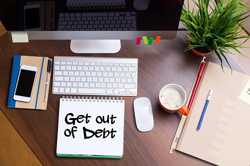 get out of debt note sitting on desk